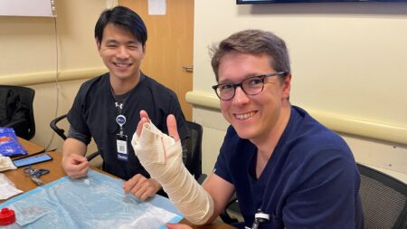 two residents practice making casts for broken bones